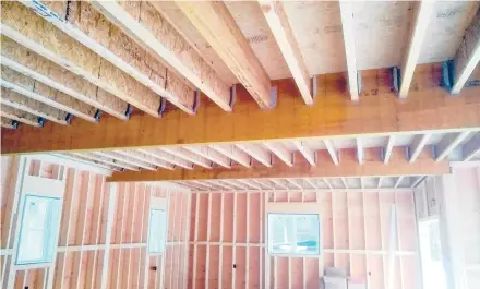  ?? TIM CARTER/TNS ?? Engineered lumber I-joists are supported by metal joist hangers in this structure.