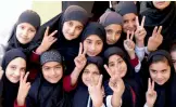  ?? — AP ?? Students of the school of Nobel Peace Prize winner Malala Yousafzai flash victory sign in her hometown of Swat Valley in Pakistan on Friday.