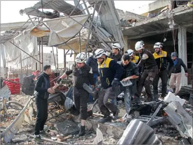  ?? (AFP) ?? Members of the Syrian Civil Defence (White Helmets) recover a victim following a regime air strike in a market in the town of Maaret Al-Numan in the province of Idlib.
