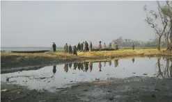  ??  ?? SRINAGAR: Kashmiri villagers stand at a dried portion of Wular Lake, northeast of Srinagar, Indian controlled Kashmir. — AP