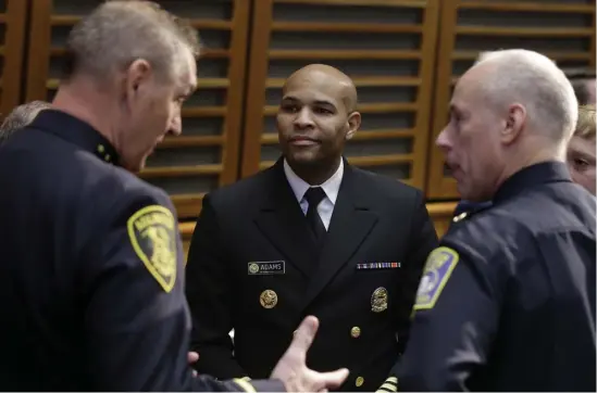  ?? AP ?? OUTREACH: U.S. Surgeon General Jerome Adams, center, speaks yesterday with Arlington police Chief Frederick Ryan, left, and others during a national summit in Boston focused on police efforts to address the opioid epidemic.