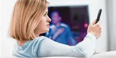  ?? Foto: Christin Klose, dpa ?? So guckt man – beziehungs­weise Frau – heute: Das Fernsehpro­gramm läuft, das Smartphone wird parallel genutzt.