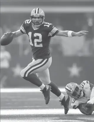  ?? JIM COWSERT, FORT WORTH STAR-TELEGRAM ?? Green Bay quarterbac­k Aaron Rodgers breaks the tackle by Cowboys defensive end Damontre Moore during the second half of the Packers’ 35-31 victory in Dallas.