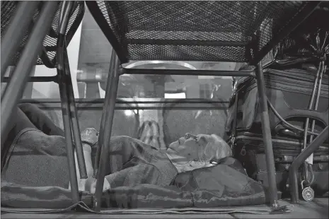  ?? LINDA DAVIDSON/THE WASHINGTON POST VIA AP ?? In this Aug. 10 photo, homeless woman Wanda Witter beds down in her sleeping spot, with suitcases in arm’s reach, outside the Au Bon Pain on 13th and G Street in Washington, D.C. Witter, who is 80 years old, was recently attacked at the location,...