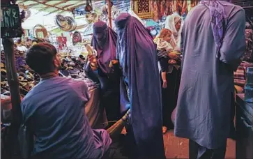  ?? Marcus Yam Los Angeles Times ?? THE TALIBAN’S “policies form a system of repression that discrimina­tes against women and girls in almost every aspect of their lives,” Amnesty Internatio­nal says. Above, women shop in a Kabul bazaar last year.