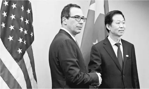  ??  ?? Treasury Secretary Mnuchin (left) shakes hands with Jie, China’s finance minister, during a bilateral meeting on the sidelines during the spring meetings of the Internatio­nal Monetary Fund (IMF) and World Bank in Washington on Apr 21. — WP-Bloomberg...