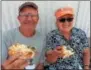  ??  ?? Charles Wagner and Susan Mitchell of Averill Park enjoy a slice of pizza, some of the wide variety of tasty food available at Saratoga County Fair.