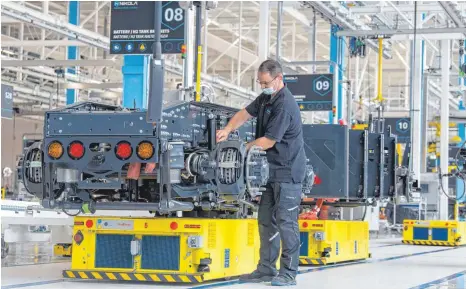  ?? FOTO: STEFAN PUCHNER/DPA ?? Ingenieur Frank Hauser bei der Kontrolle der Hinterachs­e im Chassis des Nikola Tre, der künftig in Ulm vom Band rollt: Die Serienprod­uktion soll in Kürze starten, ab 2023 soll jeden Tag ein Truck fertig werden.