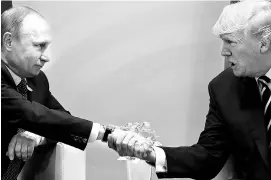  ?? REUTERS ?? A file photo of US President Donald Trump shaking hands with Russian President Vladimir Putin during their bilateral meeting at the G20 summit in Germany in July 2017