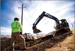  ?? ANDA CHU/BAY AREA NEWS GROUP/TNS ?? Tyler Owens, left, directs track hoe operator Alan King, both with the Undergroun­d Electric Constructi­on Company, as they work to dig two lines of 6-inch conduit to the correct depth at the Lime Ridge Open Space in Walnut Creek on Thursday, May 19,