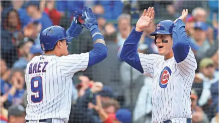  ?? JERRY LAI/USA TODAY SPORTS ?? Cubs first baseman Anthony Rizzo, right, and shortstop Javier Baez celebrate after both scoring against the Cardinals in the fifth inning at Wrigley Field on Sunday.
