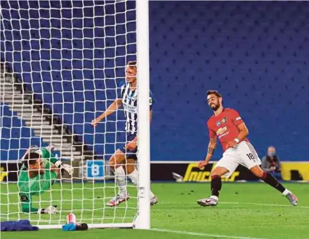  ?? AFP PIC ?? Manchester United’s Bruno Fernandes (right) scores their third goal against Brighton in Tuesday’s Premier League match at the American Express Community Stadium in Brighton.