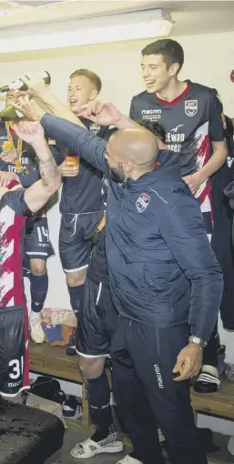  ??  ?? 0 Ross County players enjoy their triumph in the dressing room following their Irn-bru Cup final victory over Connah’s Quay Nomads. Left, captain Marcus Fraser hoists the trophy.