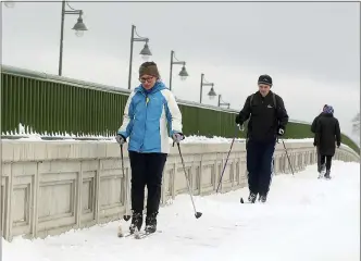  ?? ASSOCIATED PRESS FILE PHOTO ?? Erin Jaske and Scott Sandridge cross country ski across the Manette bridge in Bremerton, Wash., on a snowy day last month. During the pandemic, people around the world sought relief from lock downs and working from home in leisure sports.