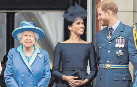  ?? FOTO: MATT DUNHAM/DPA ?? Im Juli 2018 war die Welt noch in Ordnung, als die Queen zusammen mit ihrem Enkel Harry und dessen Frau Meghan auf dem Balkon des Buckingham-Palasts den Vorbeiflug von Flugzeugen der Royal Air Force beobachtet­e.