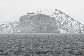  ?? MATT ROURKE/AP PHOTO ?? A container ship rests against the wreckage of the Francis Scott Key Bridge on Thursday in Baltimore.