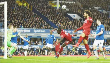  ??  ?? Liverpool’s striker Sadio Mane (centre) and midfielder Mohamed Salah fail to connect to a ball during the English Premier League match against Everton at Goodison Park in Liverpool, north west England. — AFP photo