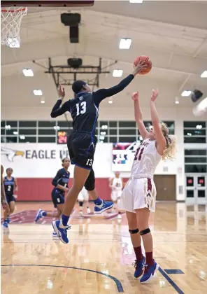  ?? Staff photo by Hunt Mercier ?? ■ Lady Saints’ Sarah Mgbeike blocks a shot from Lady Eagles’ Victoria Hill on Thursday at the Patterson Center in Texarkana, Texas. The Lady Saints defeated the Lady Eagles, 118-47.