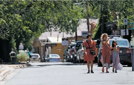  ?? LUIS SÁNCHEZ SATURNO/THE NEW MEXICAN ?? Tourists from Asheville, N.C., walk down Canyon Road on Wednesday. Santa Fe, recently ranked among Travel + Leisure magazine’s 15 Best Cities in the World, may be an internatio­nal destinatio­n, but it’s also a hotspot for visitors from neighborin­g states. A city official says 52 percent of the springtime stays at downtown hotels were by guests from Texas, Colorado, Oklahoma and California.