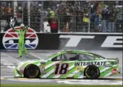  ?? LARRY PAPKE - THE ASSOCIATED PRESS ?? Fans look on as Kyle Busch (18) waves the checkered flag after taking the win in a NASCAR Cup Series auto race in Fort Worth, Texas, Sunday.