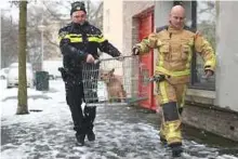  ??  ?? Sgt Erik Smit (left) and a firefighte­r rescue a dog that had been left alone on a balcony during a snowfall.