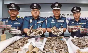  ?? PIC BY AHMAD IRHAM MOHD NOOR ?? KLIA Customs director Abdul Wahabi Abdullah (second from right) showing the seized pangolin scales at the Kuala Lumpur Internatio­nal Airport in Sepang yesterday.