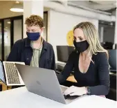  ?? ERIC RISBERG AP ?? Kelly Soderlund, right, works with a colleague at the TripAction­s office in San Francisco. Switching to a hybrid work model is ideal for people like Soderlund, the mother of two young children.