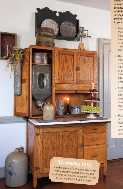  ??  ?? Minimal decorative accents allow this antique Hoosier cabinet with an intact flour bin to play a starring role in the kitchen. Stoneware pieces enhance the cabinet’s rustic feel without competing with its beautiful wood grain and hardware. Placing two large accents of equal height and weight on top, like this glass butter churn and firkin, provides visual balance.