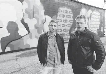  ?? JASON KRYK ?? Artists Colin MacDonald, left, and David Creed show off the latest mural commission­ed by Art Attack Windsor outside the home of the Multicultu­ral Council of Windsor and Essex County.