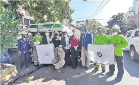  ??  ?? Los bomberos celebran la adquisició­n de la nueva ambulancia, que aparece detrás, frente a la Fiscalía de San Lorenzo.