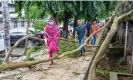  ?? Photograph: Monirul Alam/EPA ?? People walk past trees brought down by Cyclone Sitrang, Dhaka, Bangladesh.