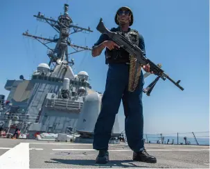  ?? (US Naval Forces Central Command/US 5th Fleet/Handout via Reuters) ?? A US NAVY master-at-arms stands watch on the ‘USS Paul Hamilton’ during a Strait of Hormuz transit.