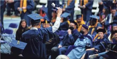  ?? MEGAN MENDOZA/THE REPUBLIC ?? A Northern Arizona University graduate holds up a degree while leaving the stage at NAU’s spring 2023 commenceme­nt at the NAU Skydome on May 13, 2023, in Flagstaff.