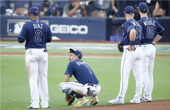  ?? GETTY IMAGES ?? Yandy Diaz, Willy Adames, Michael Brosseau and Joey Wendle of the Rays look on during a pitching change in the seventh inning. The Rays’ pen let its team down in Game 6.