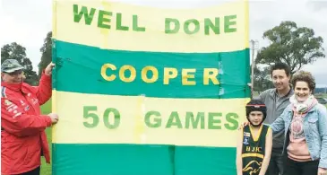  ??  ?? Hallora under 12 player Cooper Wright celebrated his 50th game with his grandfathe­r John and parents Daniel and Felicity.