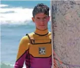  ??  ?? Ali Kassem, holding his surfboard on a beach in the town of Jiyeh.