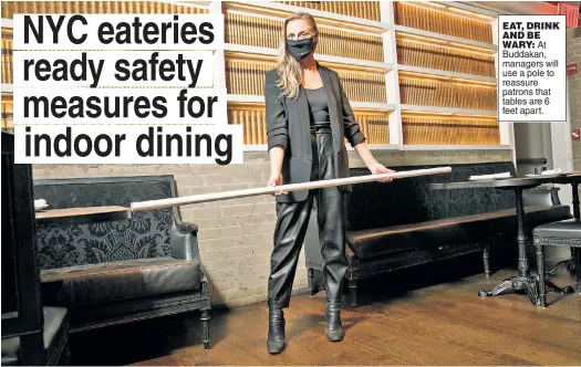  ??  ?? EAT, DRINK AND BE WARY: At Buddakan, managers will use a pole to reassure patrons that tables are 6 feet apart.