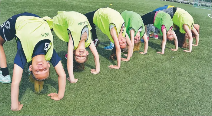  ?? FOTO:CHARLOTTE ÅRLING ?? IDLAFLICKO­RNA. Några tjejer kör gymnastik på gräsmattan tillsamman­s med Team Pannbens ledare Eric Hedqvist, som faktiskt står i brygga men är gömd längst bak i bilden.