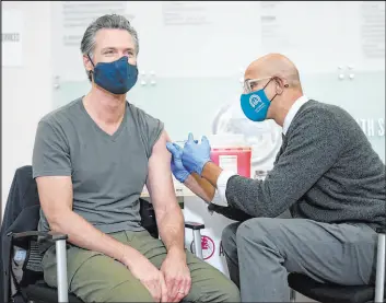  ?? Jeff Chiu The Associated Press ?? California Gov. Gavin Newsom receives a Moderna COVID-19 vaccine booster shot Wednesday in Oakland from Health and Human Services Secretary Dr. Mark Ghaly.