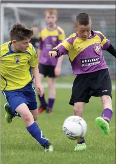  ??  ?? Jamie Lyng (New Ross Town) watches CallumFarr­ell (Wexford Albion) launching an attack for the home team.