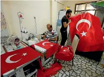  ??  ?? Workers make Turkish flags at a small flag factory in Istanbul.