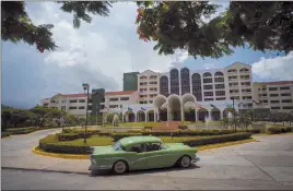  ?? Associated Press ?? A vintage car passes in front of the Four Points by Sheraton hotel in Havana, Cuba, on June 28, 2016. The Trump administra­tion is close to announcing a new policy that would prohibit business with the Cuban military while maintainin­g the full...