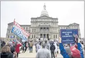  ?? MATTHEW DAE SMITH — LANSING STATE JOURNAL VIA AP ?? Rallygoers protest earlier this month at the Michigan Capitol in Lansing, Mich.