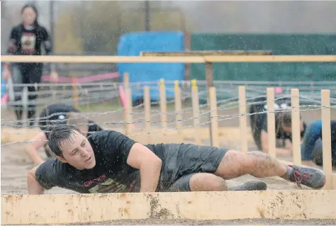  ?? PHOTOS: MICHAEL ?? Crawling or sliding along the mucky ground was all part of the fun for participan­ts in Mud, Sweat and Tears in Lumsden on Saturday.