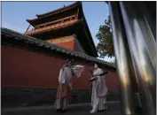  ?? NG HAN GUAN — THE ASSOCIATED PRESS ?? Residents wearing traditiona­l gowns take photos near the drum tower on Sunday in Beijing. Many Chinese marked a quiet May Day this year as the government's “zero-COVID” approach restricts travel and enforces lockdowns in multiple cities.