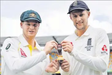  ?? AFP ?? Skippers Steve Smith (left) of Australia and England’s Joe Root pose with a replica of the Ashes urn in Brisbane on Wednesday.