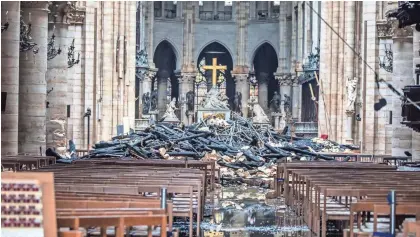  ?? POOL PHOTO BY CHRISTOPHE PETIT TESSON ?? Before firefighte­rs could extinguish the Notre Dame inferno, it claimed the spire and roof but spared the towers.