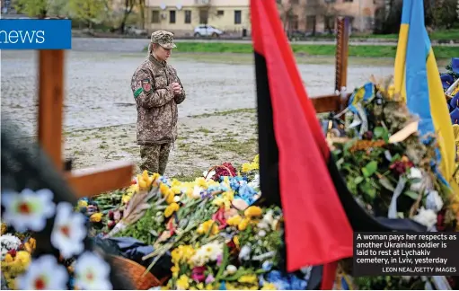  ?? LEON NEAL/GETTY IMAGES ?? A woman pays her respects as another Ukrainian soldier is laid to rest at Lychakiv cemetery, in Lviv, yesterday