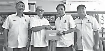  ??  ?? Rosli (second right) receiving his appointmen­t letter as Labuan Warisan secretary from Rozman.