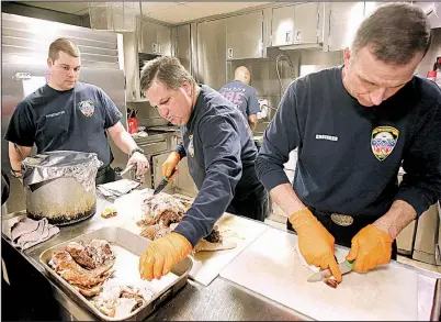  ?? Arkansas Democrat-Gazette/THOMAS METTHE ?? Little Rock firefighte­r Keith Lovell (right) and Capt. Jackie Rankin carve turkeys before Thanksgivi­ng dinner Thursday at Fire Station 1.